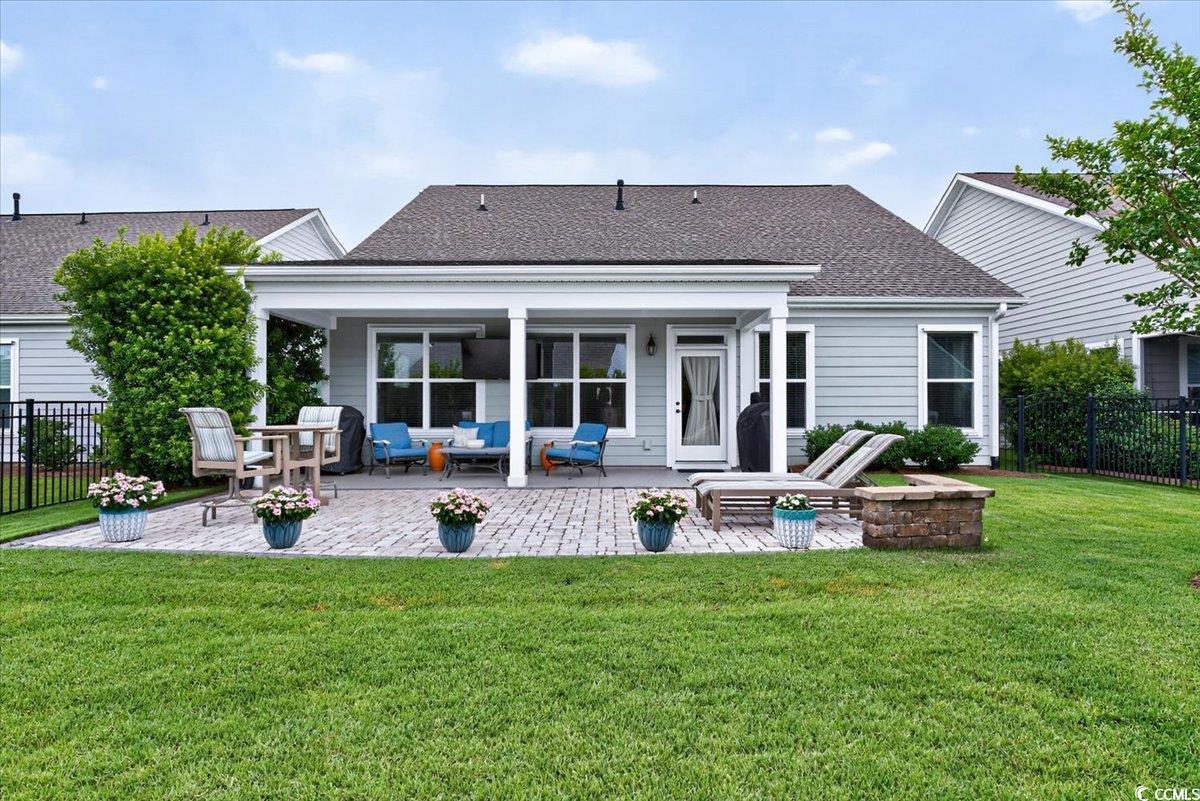 Back of property with an outdoor living space, a shingled roof, and a patio