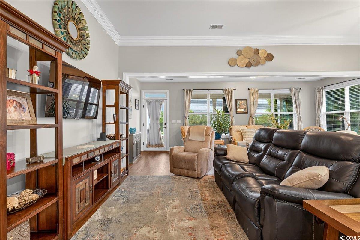 Living room with crown molding and wood finished floors