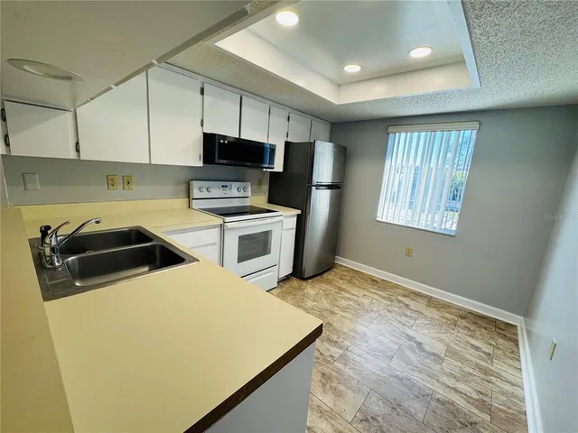 a kitchen with stainless steel appliances granite countertop a sink a stove a microwave and a refrigerator