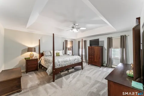 a spacious bedroom with a bed table and window