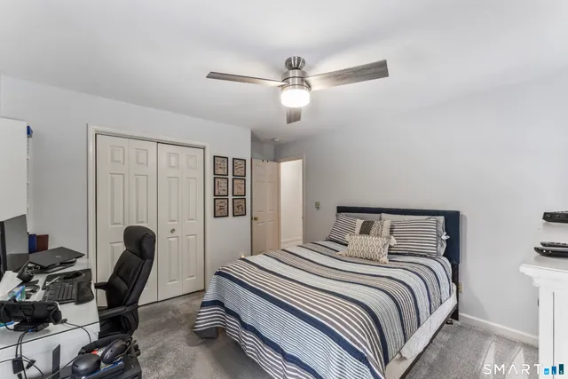 a bedroom with a bed a chair and a large window