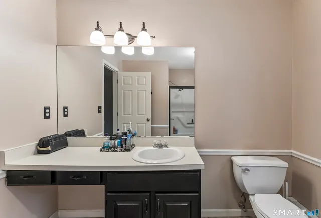 a bathroom with a sink a toilet and a mirror