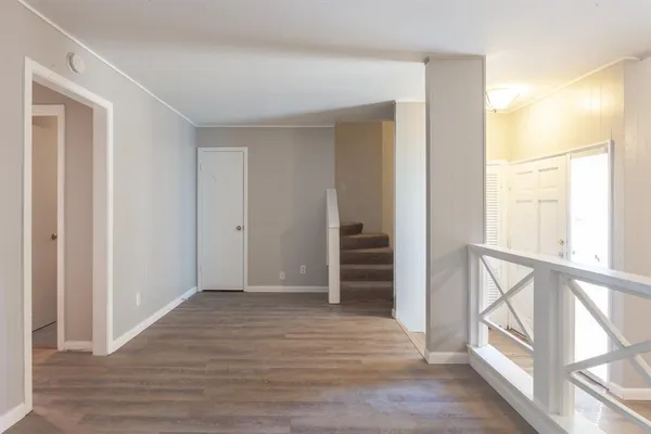 a view of empty room with wooden floor and window