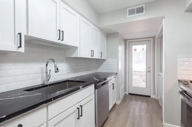 a kitchen with granite countertop a sink and cabinets