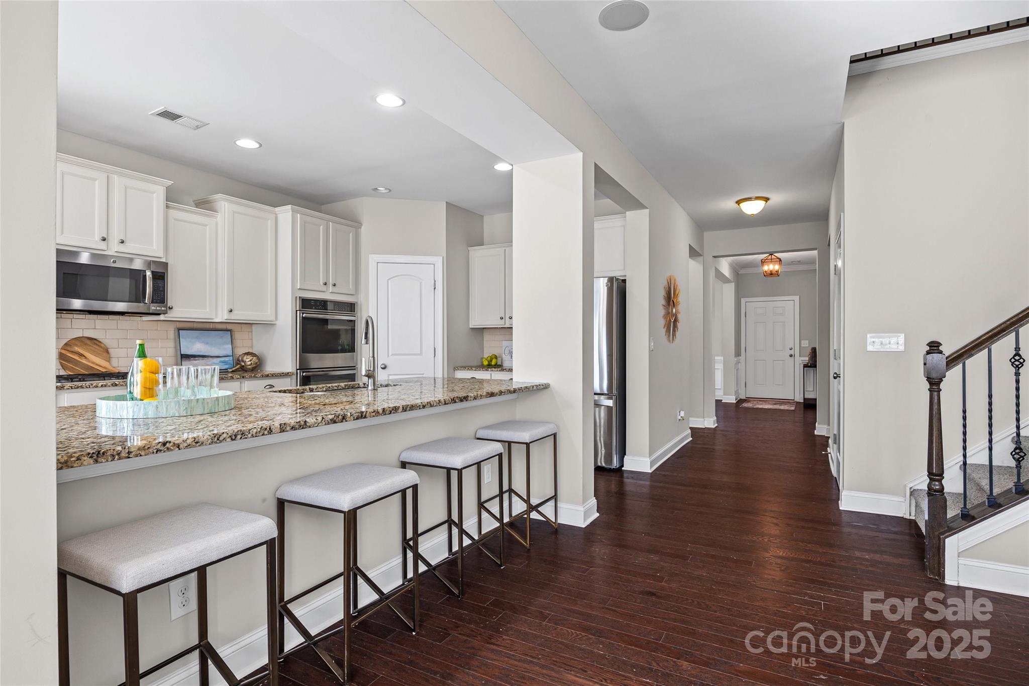 84324 Masterson Court Lancaster, SC 29720 - Photo 15 of 45 a large kitchen with stainless steel appliances granite countertop a stove a sink a refrigerator and white cabinets with wooden floor
