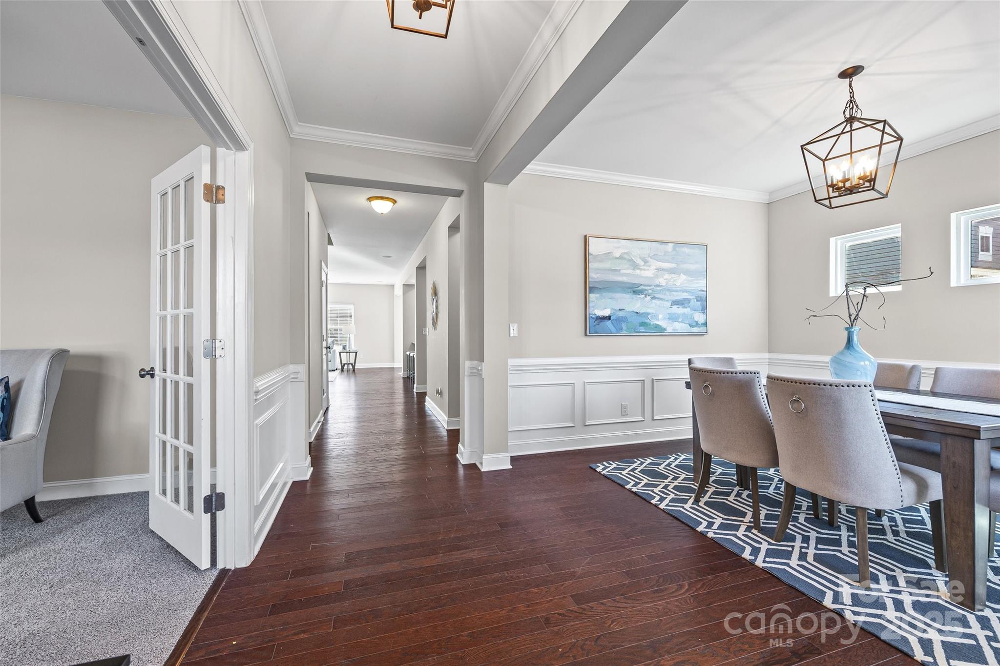 84324 Masterson Court Lancaster, SC 29720 - Photo 5 of 45 a dining room with wooden floor a chandelier a wooden table and chairs