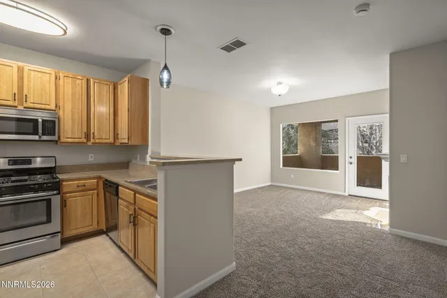 a kitchen with stainless steel appliances granite countertop a stove a sink and a microwave