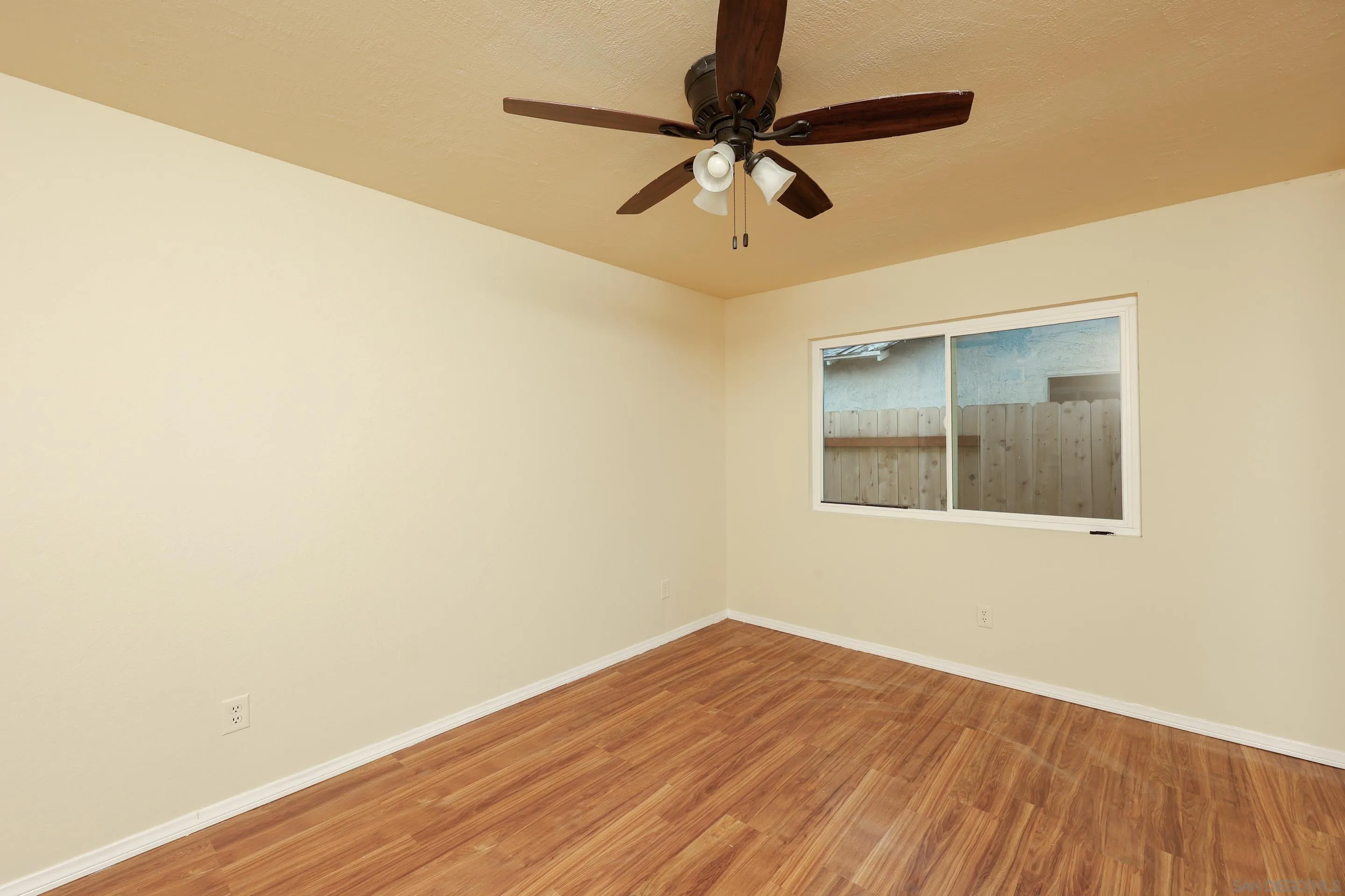 10866 Sandy Hook Road San Diego, CA 92126 - Photo 13 of 15 a view of a room with wooden floor and a ceiling fan