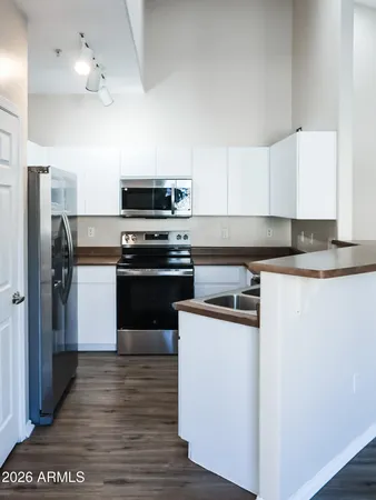 a kitchen with stainless steel appliances granite countertop a stove a sink and a refrigerator