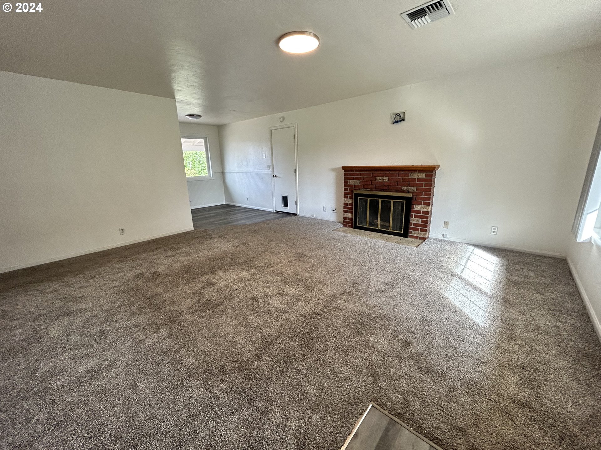 5736 Thurston Road Springfield, OR 97478 - Photo 10 of 38 an empty room with a fireplace and window