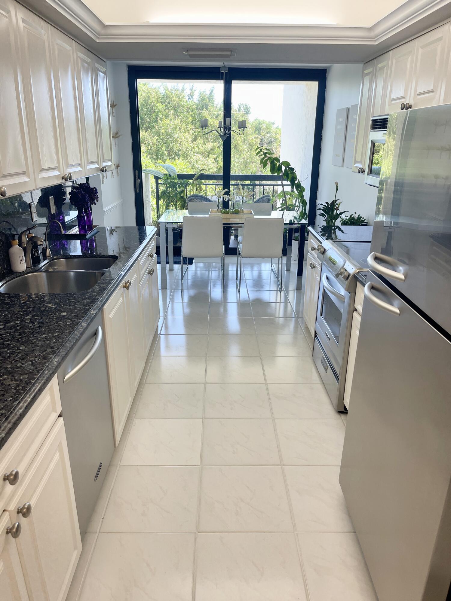 2001 North Ocean Boulevard, Unit 301 Boca Raton, FL 33431 - Photo 11 of 41 a kitchen with stainless steel appliances a sink a counter top space and a large window