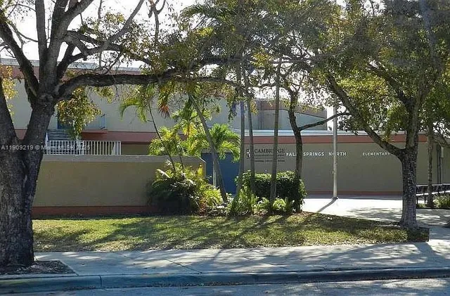 a view of a house with a yard and potted plants