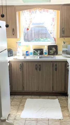 a kitchen with a refrigerator a stove a sink and a window