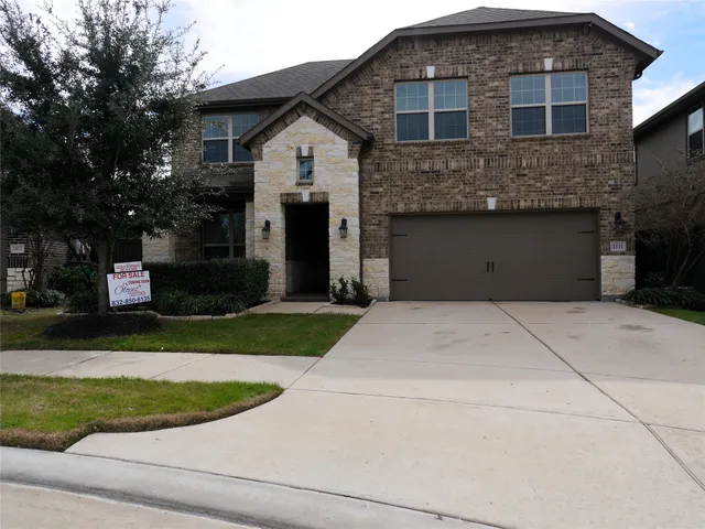 a front view of a house with a garden and tree