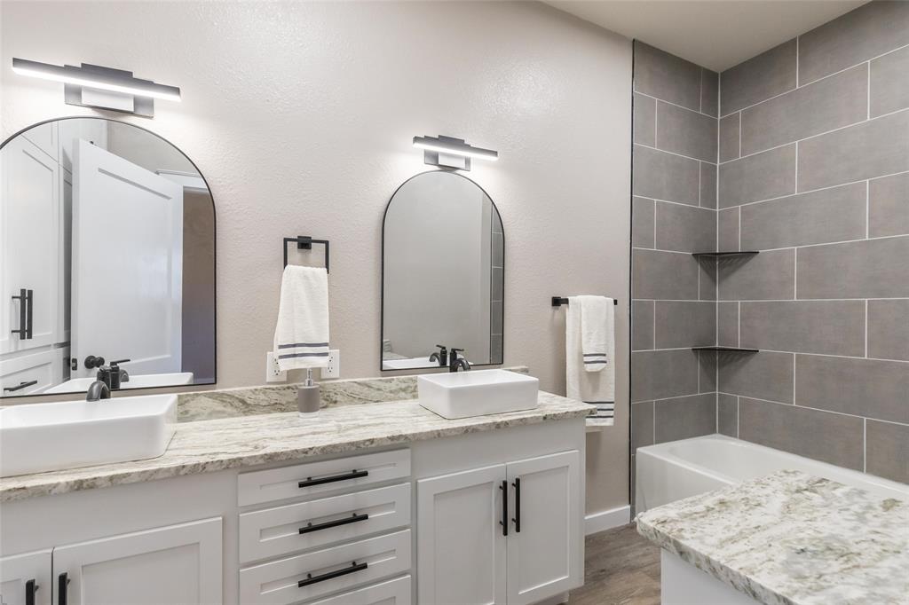 601 North Ave G Haskell, TX 79521 - Photo 21 of 36 a bathroom with a granite countertop sink a mirror and a