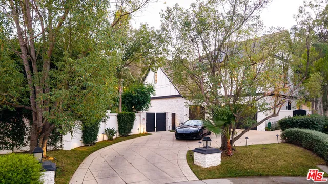 an aerial view of residential house with outdoor space and trees all around