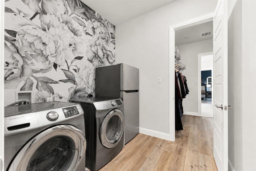 6404 Trezevant Street Rowlett, TX 75089 - Photo 25 of 30 Laundry area with decorative accent wall featuring a floral pattern, wood-finish flooring, and white baseboards