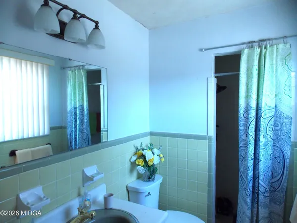 a bathroom with a shower sink and mirror