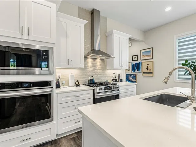a kitchen with a sink a stove oven a counter space and cabinets