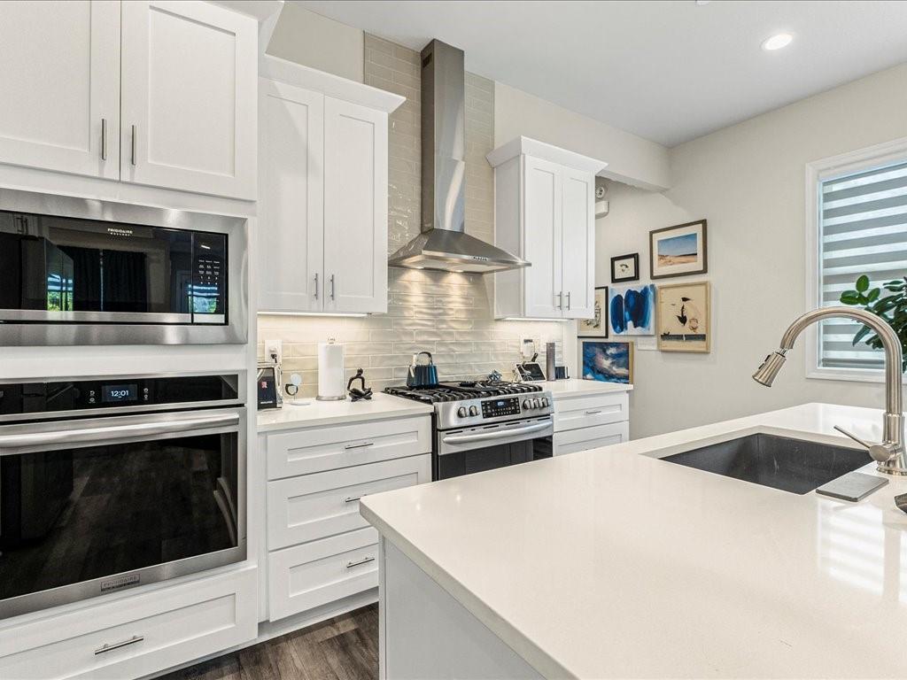 120 Via Roma Woodstock, GA 30188 - Photo 8 of 46 a kitchen with stainless steel appliances white cabinets and stove