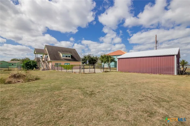 a view of a big yard with an tree and wooden fence