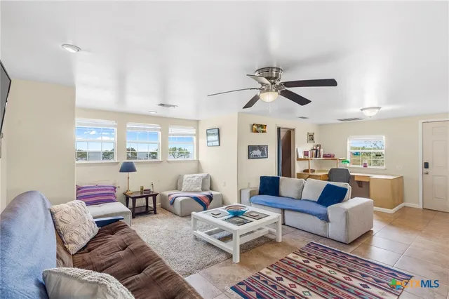 a living room with furniture ceiling fan and a rug