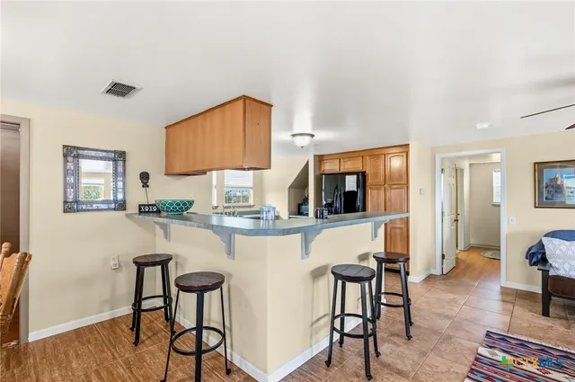 a kitchen with stainless steel appliances granite countertop table chairs sink and cabinets