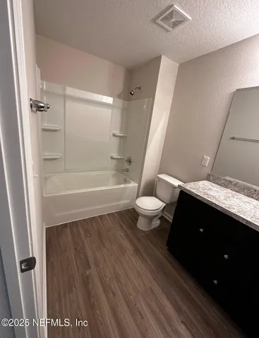 a bathroom with a sink a toilet a tub and shower