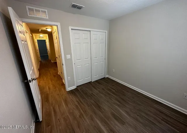 an empty room with wooden floor and entrance