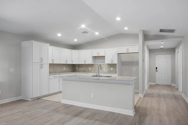 a kitchen with kitchen island a sink stainless steel appliances and cabinets