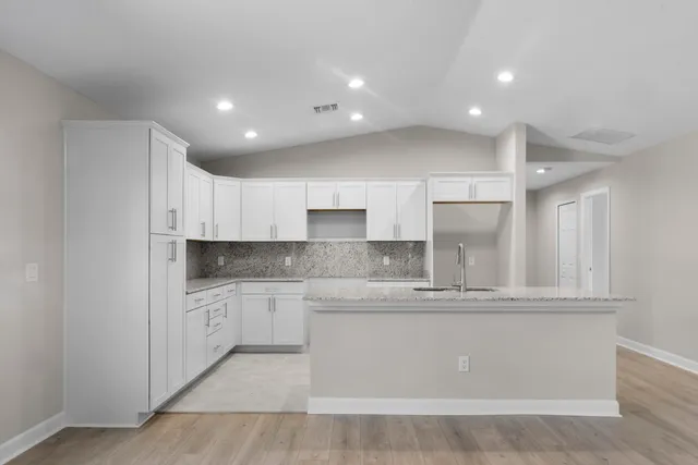 a large kitchen with stainless steel appliances granite countertop a stove a sink and a refrigerator