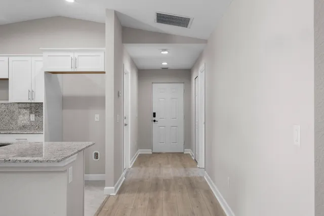 a view of a hallway with wooden floor