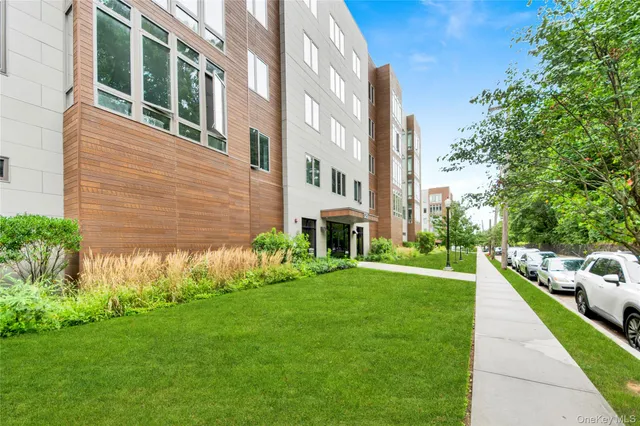 a view of a brick house with a yard and plants
