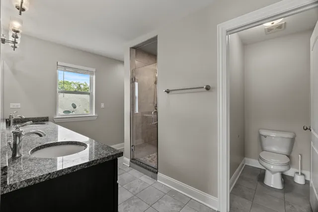 a bathroom with a granite countertop sink toilet and shower