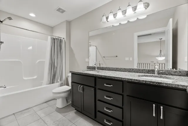 a bathroom with a granite countertop sink a toilet and a bathtub