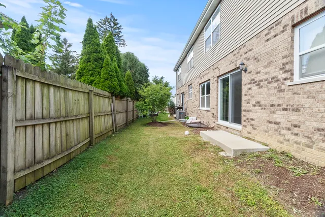 a view of a backyard with brick wall and wooden fence