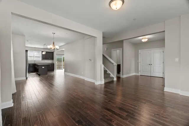 a view of a livingroom with wooden floor and staircase