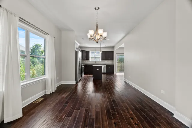 a view of a room with wooden floor fireplace and windows
