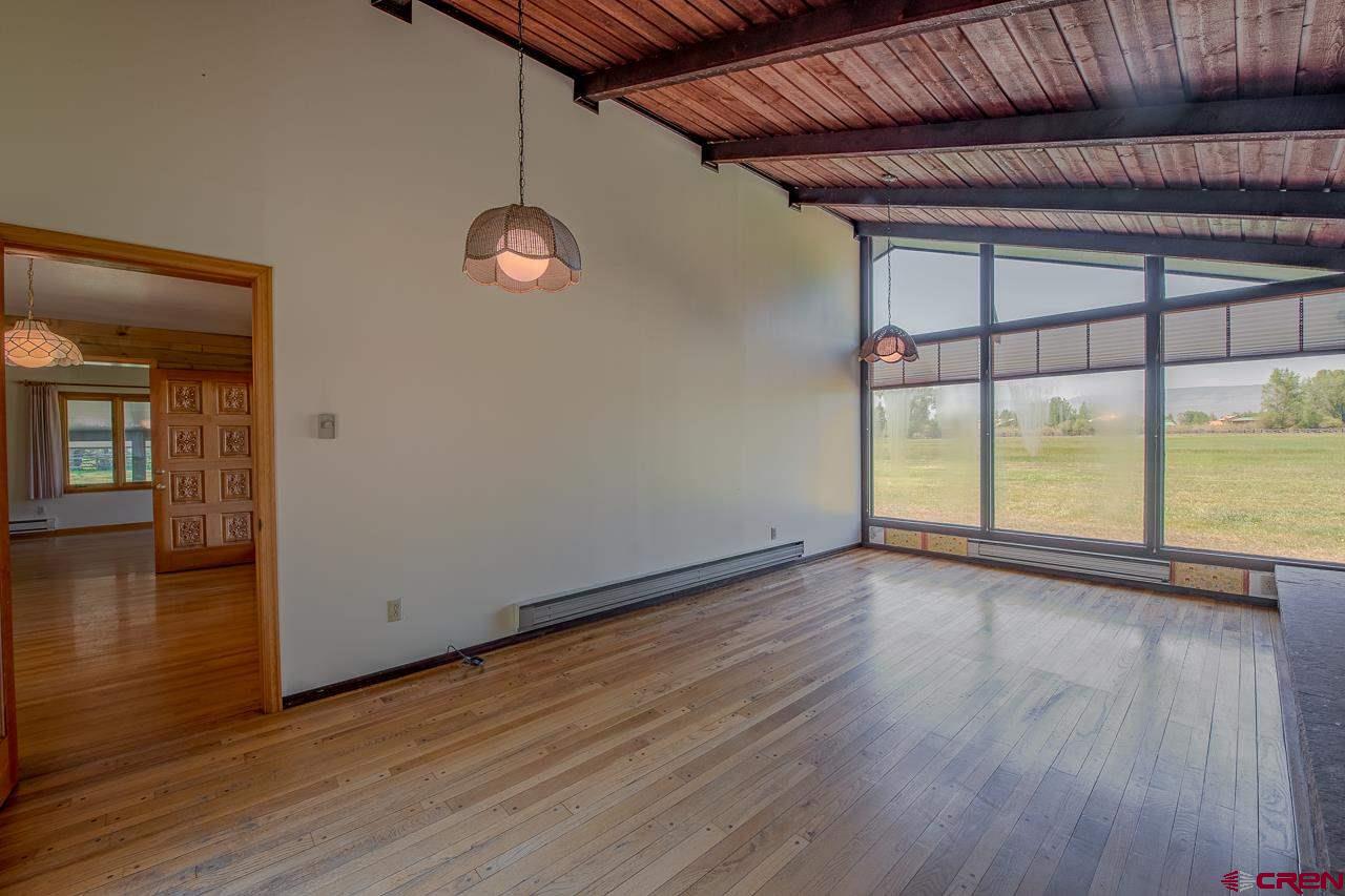171 Arapahoe Road Gunnison, CO 81230 - Photo 12 of 34 Sunny views with floor to ceiling windows, wood burning fireplace and hardwood floors.