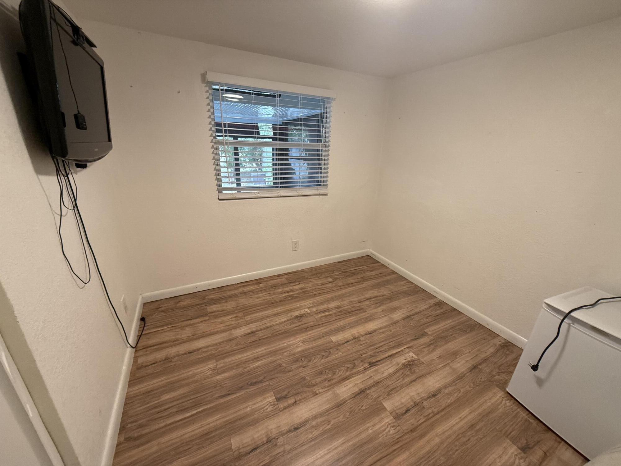 1660 Southwest 65th Avenue Boca Raton, FL 33428 - Photo 8 of 14 a view of a room with wooden floor and a ceiling fan
