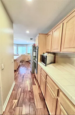 a kitchen with a refrigerator a stove top oven and wooden floor