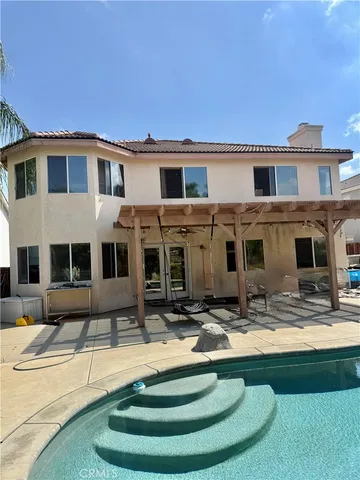 a view of a house with swimming pool and sitting area