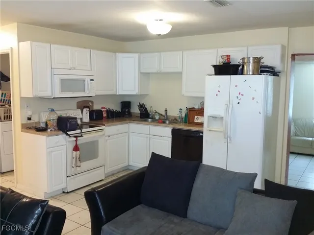 a kitchen with a refrigerator sink and cabinets