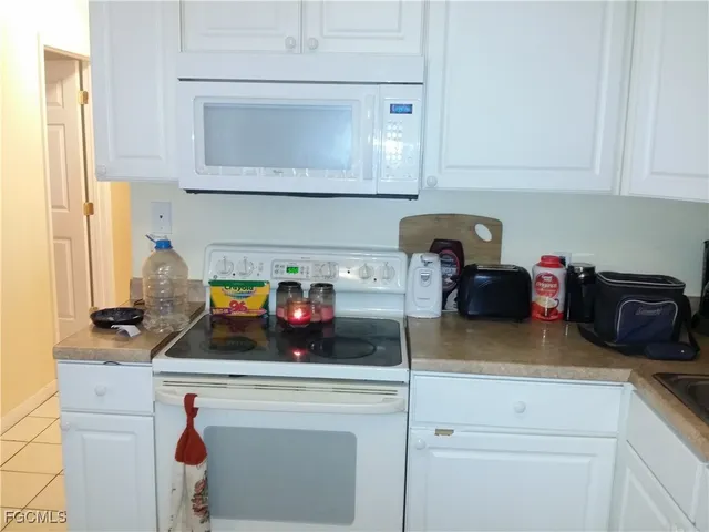 a kitchen with appliances a sink and cabinets