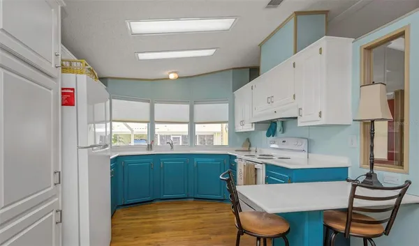 a kitchen with stainless steel appliances a refrigerator a sink a stove a dining table and chairs
