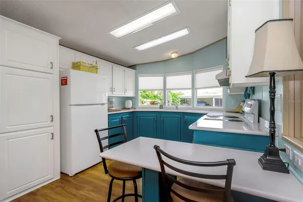 a kitchen with stainless steel appliances granite countertop a sink and cabinets with wooden floors