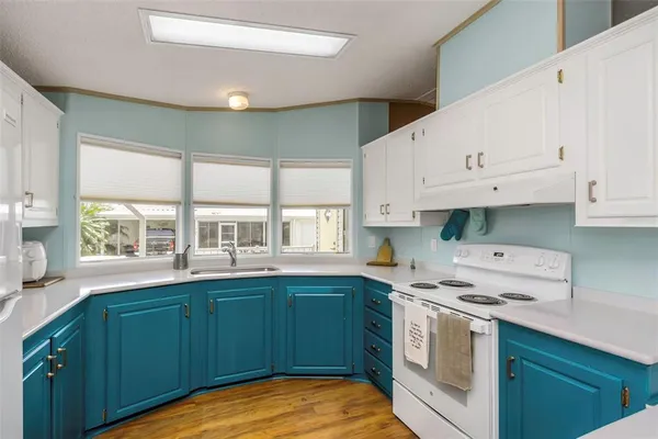 a kitchen with granite countertop white cabinets and white appliances