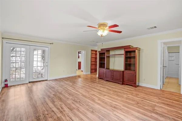 a view of an empty room with window and wooden floor