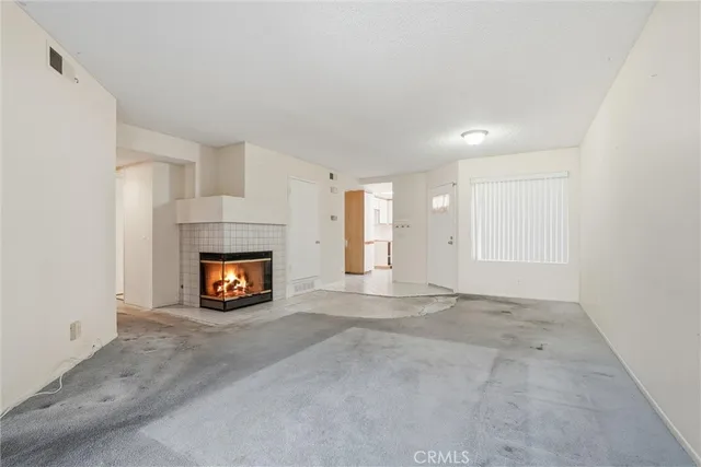 an empty room with a fireplace and a window