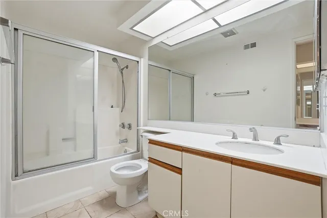 a bathroom with a granite countertop sink toilet a shower and a mirror